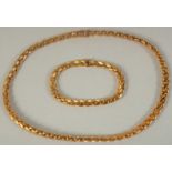 A .750 GOLD CHAIN, 15.5ins long and a matching BRACELET, 7ins long, 57gms.