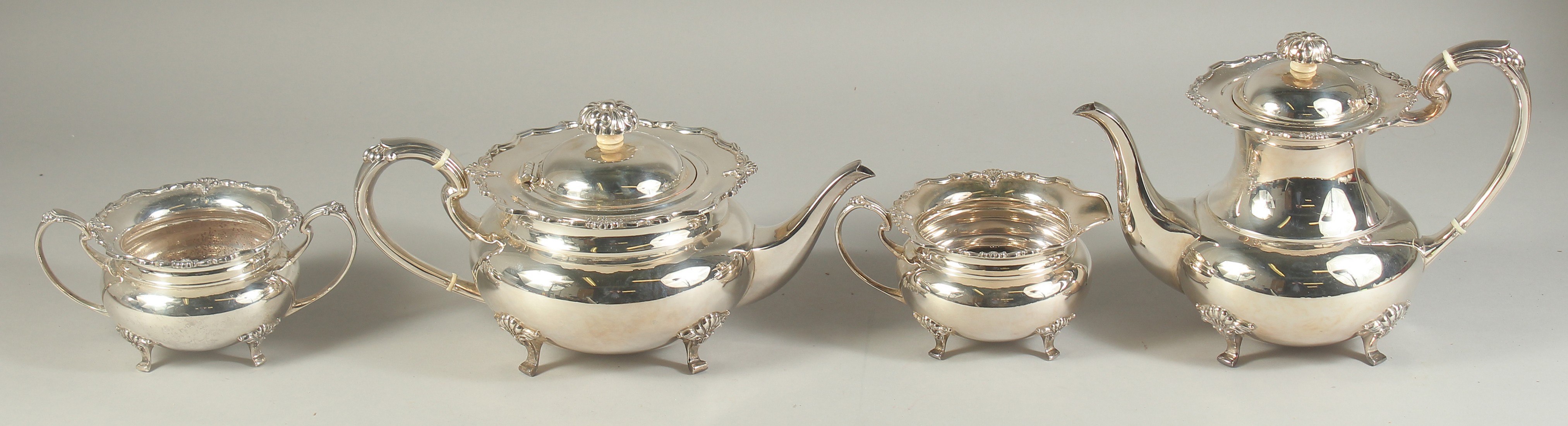 A VERY GOOD FOUR PIECE SILVER CIRCULAR TEA SET of pie crust design with shell mounts, comprising: