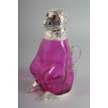 A SILVER PLATED RUBY GLASS CLARET JUG with glass eyes.