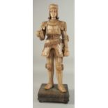 A GOOD LIMEWOOD CARVING OF A MID 15TH CENTURY NOBLEMAN, wearing armour, from the solid, on a