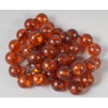 AN AMBER GRADUATED BEAD NECKLACE, 22ns long, 40 beads. 37gms.