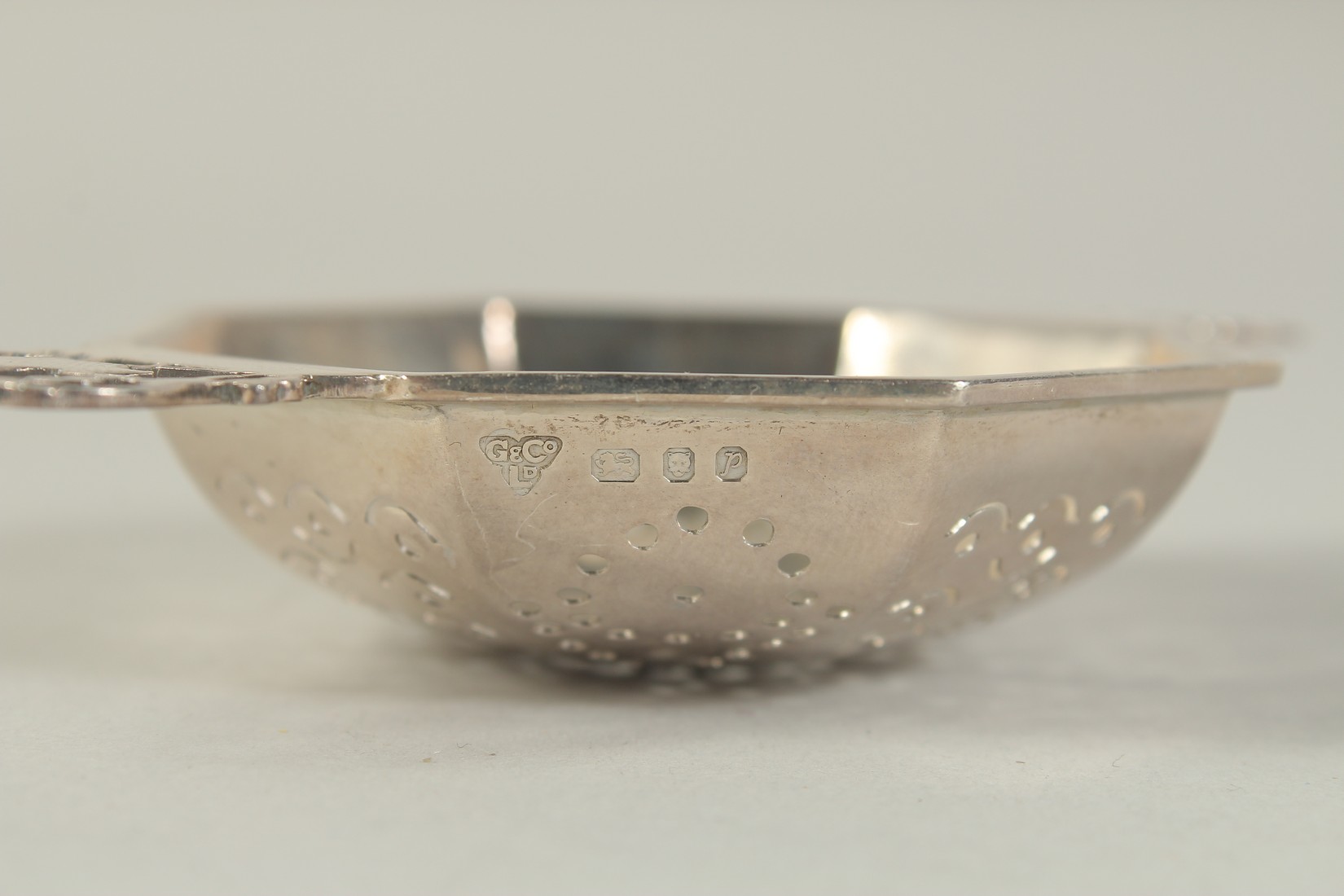 A TWO HANDLED SILVER TEA STRAINER. - Image 3 of 3