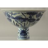 A CHINESE PORCELAIN BLUE AND WHITE STEM CUP painted with fish. 6.5ins high.