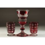 A GOOD BOHEMIAN RUBY GOBLET etched with four buildings. 8ins high and A PAIR OF BEAKERS 4ins