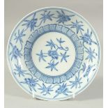 A CHINESE BLUE AND WHITE PORCELAIN DISH, decorated with flora. 21cm diameter.