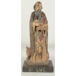 A GOOD 17TH CENTURY CARVED WOOD AND POLYCHROME FIGURE, ST. LUC, on a wooden base. 1ft 11ins high.