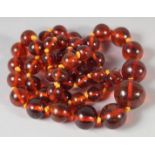 A GOOD GRADUATED AMBER BEAD NECKLACE, 50 beads, 22ins long, 28gms.