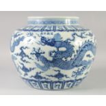 A LARGE CHINESE BLUE AND WHITE PORCELAIN JARDINIERE, painted with dragons and bands of characters,