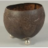 A CARVED COCONUT BOWL on ball feet.