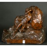 A Continental wood carving of a nude male figure moving a rock bearing figureheads, circa 1900,