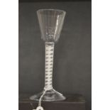 An 18th century English wine glass with inverted bowl and air twist stem.