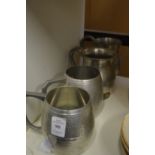 Four pewter tankards.