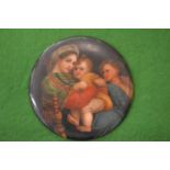 A small circular porcelain plaque painted with mother and children.