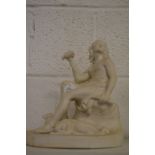 A parian ware seated figure with dogs at his feet.