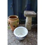 A bird bath and two planters.