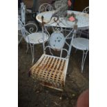 A pair of white painted metal folding garden chairs.