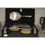 A cased silver backed six piece dressing table set.