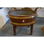 A George III mahogany and brass bound oval wine cooler or jardiniere on stand.