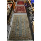 A blue ground bokara style rug, 160cm x 97cm together with two small red ground Persian rugs,