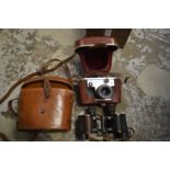 A pair of Bausch and Lomb binoculars, cased and a Corfield Periflex camera with leather case.