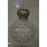 A hobnail cut glass scent bottle with hinged embossed silver lid.