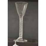 An 18th century English wine glass with inverted bowl and air twist stem.