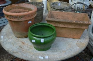A green glazed planter and two terracotta plant pots.