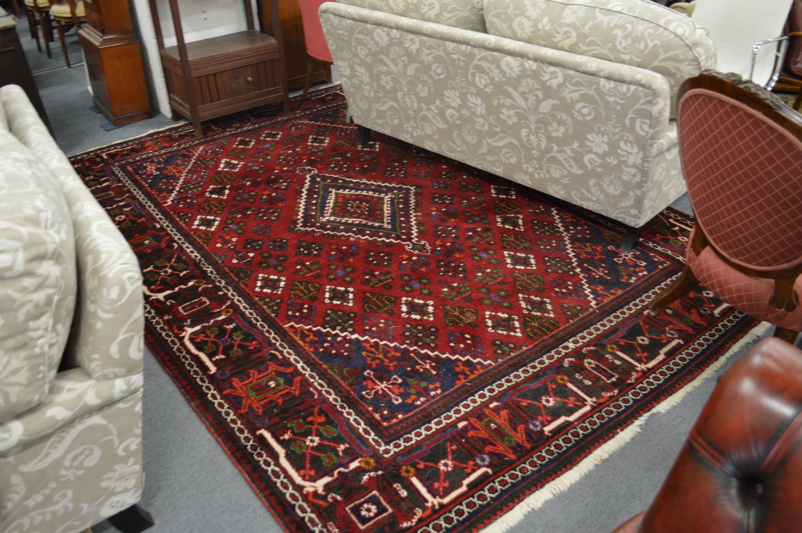 A large Persian design carpet, red ground with stylised decoration, 300cm x 222cm.