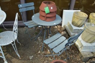 A grey painted metal bistro set comprising table and pair of folding chairs.