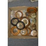 A collection of pot lids, mostly framed.