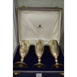 A cased set of Asprey & Co silver wine goblets, engraved with initials.