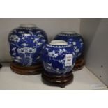 Three Chinese blue and white prunus pattern ginger jars on associated stands.