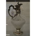 A good cut glass claret jug with embossed silver mounts.