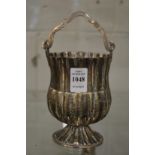 A hammered white metal pedestal swing handle basket.