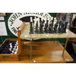 An oynx chess table, a chess set and spare chess pieces.