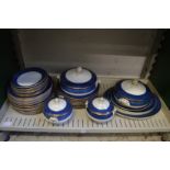 A quantity of blue and gilt decorated dinner ware.