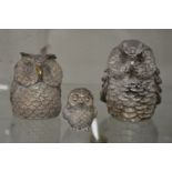 A set of three silver overlaid models of owls.