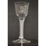 An 18th century English wine glass with inverted bowl and air twist stem.