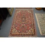 A Persian rug, pink ground with floral decoration, 168cm x 103cm.