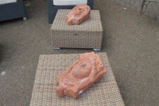 A pair of terracotta wall mask planters.