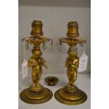 A pair of ormolu cherub form candlesticks converted to electricity.