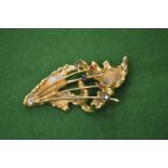 An 18ct gold and gem set brooch of naturalistic form.