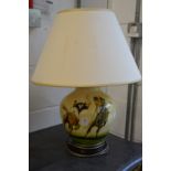 A pottery table lamp painted with a polo playing scene.