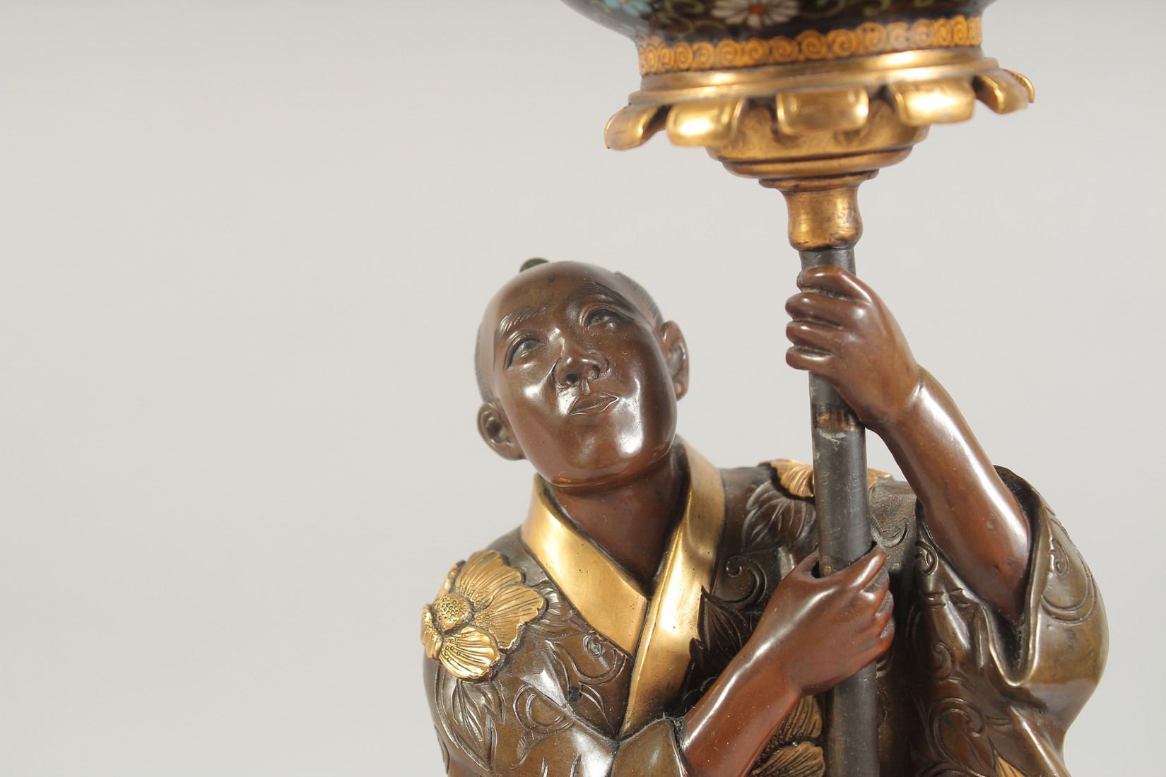 A FINE JAPANESE MEIJI PERIOD BRONZE OKIMONO holding a cloisonne urn aloft, the figure with gilt - Image 5 of 8