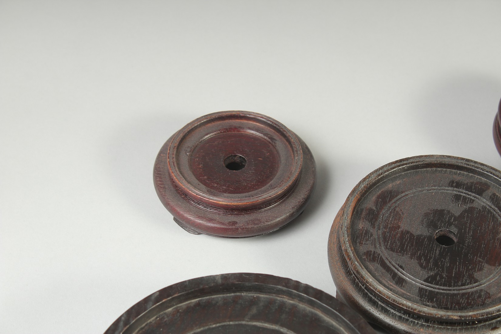 A COLLECTION OF EIGHT CHINESE HARDWOOD STANDS, various sizes, largest 17.5cm diameter. - Image 6 of 7