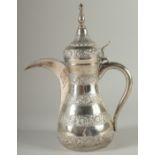 AN ISLAMIC SILVER EWER, with hinged cover and curving handle, curving spout, with alternating