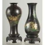 TWO BLACK AND GILT PAPIER MACHE VASES mounted to hardwood stands, 17.5cm high, (2).