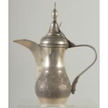 A 19TH CENTURY ARABIC ENGRAVED SILVER COFFEE POT, with hinged lid and strapwork handle, curving