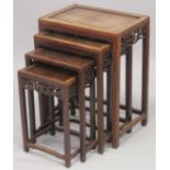 A GOOD CHINESE HARDWOOD NEST OF TABLES, comprising four graduating tables with carved frieze and