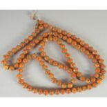 A LONG AMBER-STYLE BEADED NECKLACE.